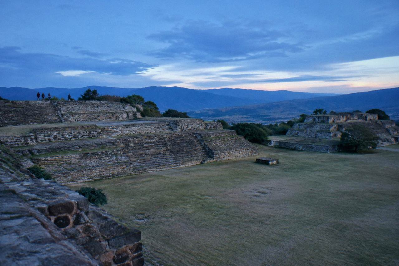 Stone terraces and platforms of an ancient hilltop site above a valley in Oaxaca