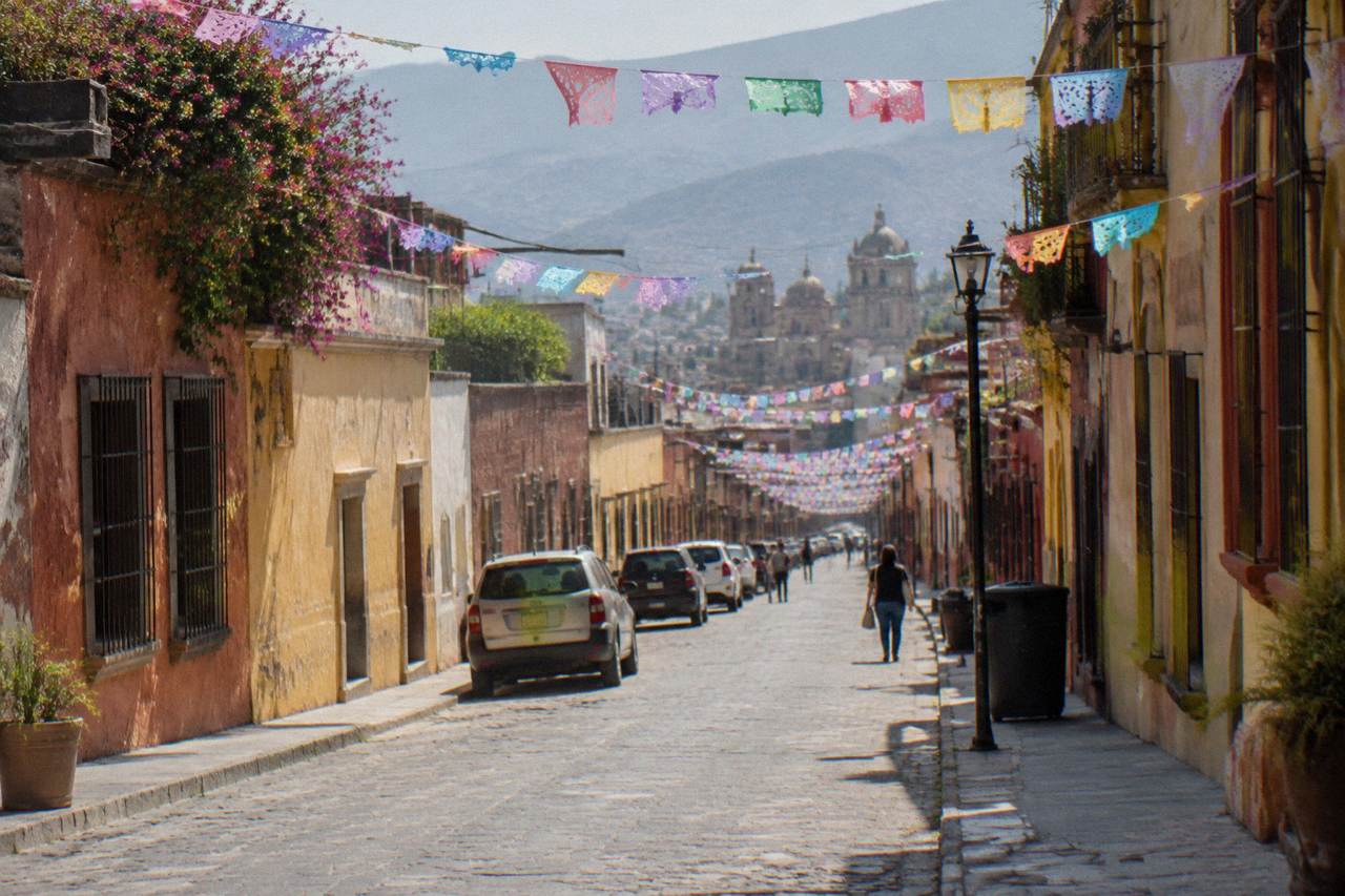 A colourfully painted colonial street in Oaxaca City with paper flags strung overhead