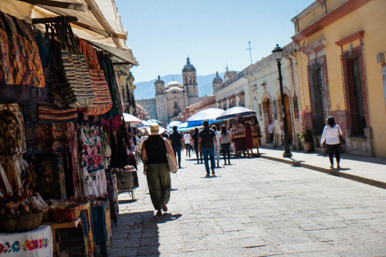 A busy market street in the historic centre of Oaxaca City with vendors and colonial buildings