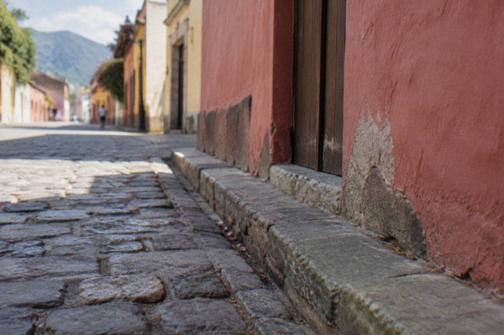Cobblestones and a low painted facade along a street in Jalatlaco, Oaxaca City