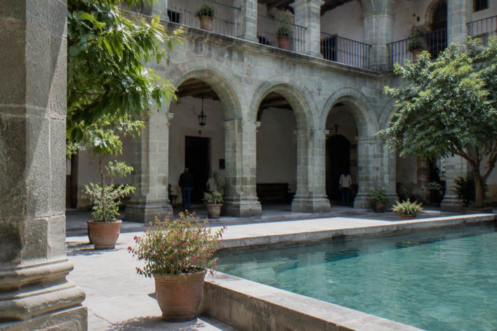 A courtyard of green stone arches in a former convent building in Oaxaca City