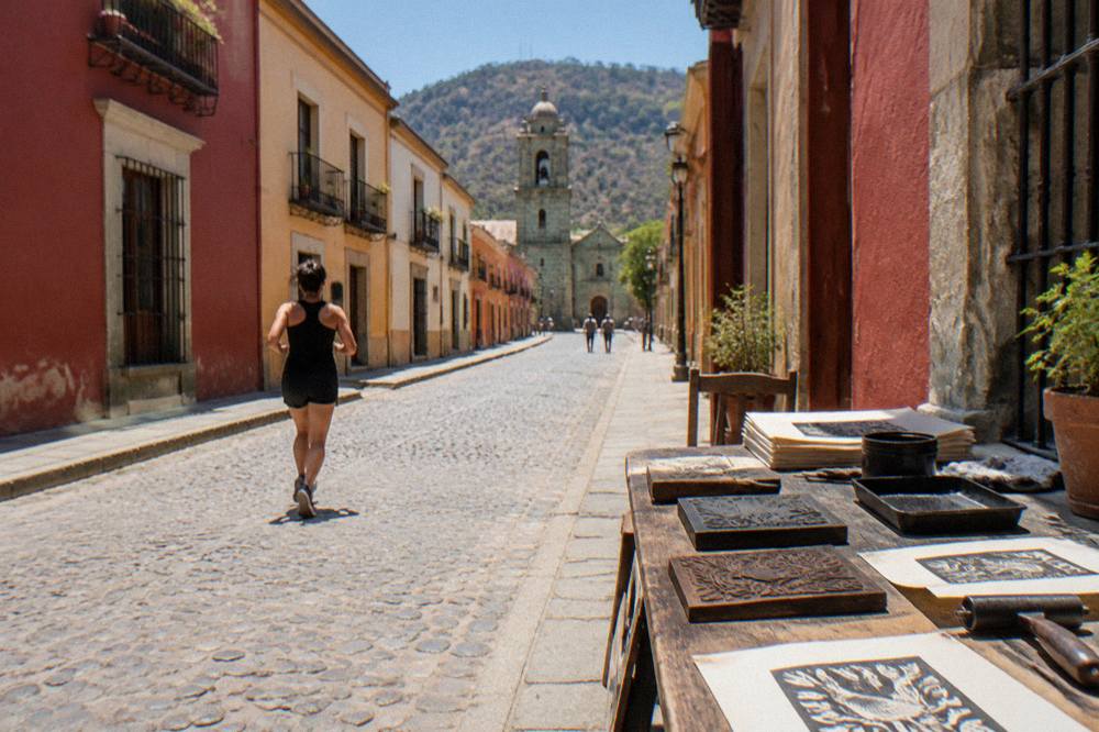 A printmaking workshop table in Oaxaca with carved blocks, ink and printed paper