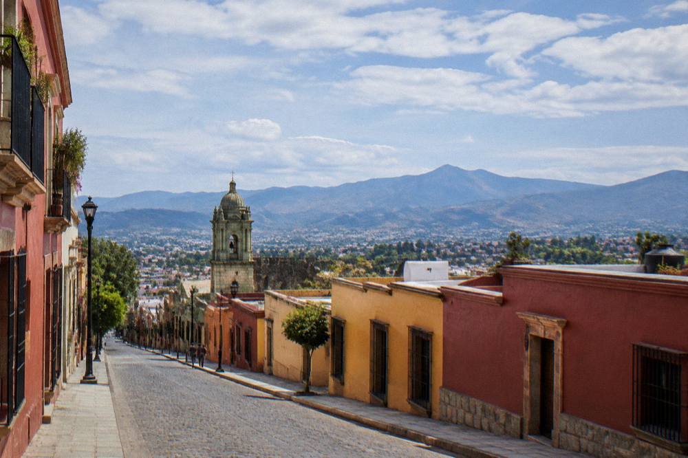 View over rooftops of Oaxaca City with the valley and mountains on the horizon