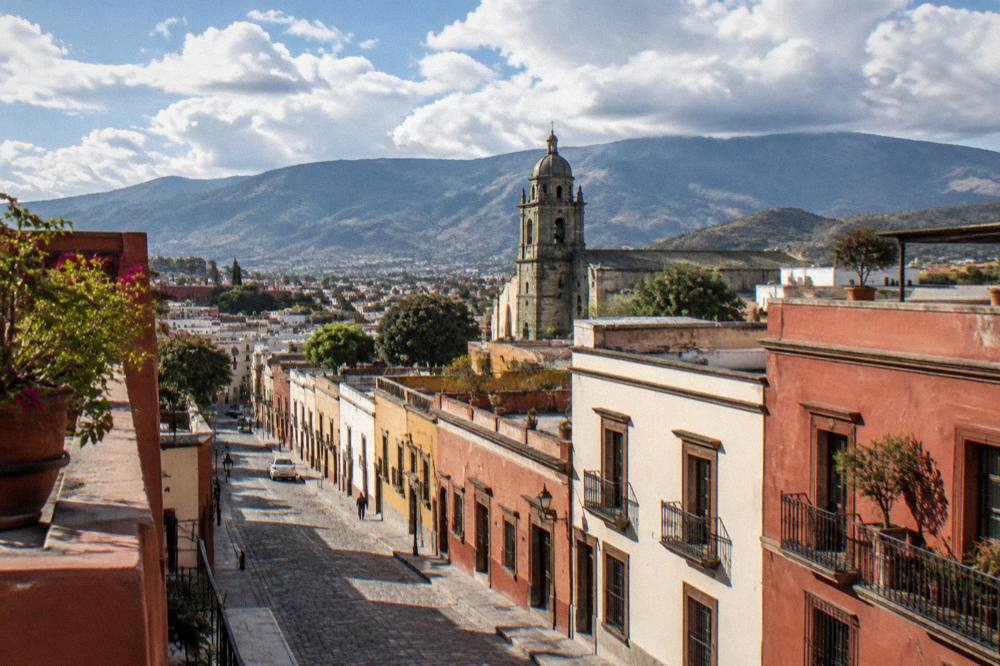 A view over the rooftops of Oaxaca City towards the surrounding mountains