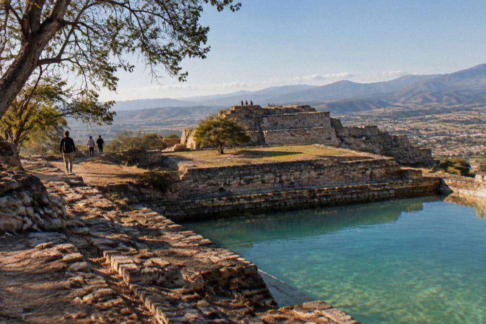 Terraced stone ruins on a hilltop overlooking a wide valley in Oaxaca