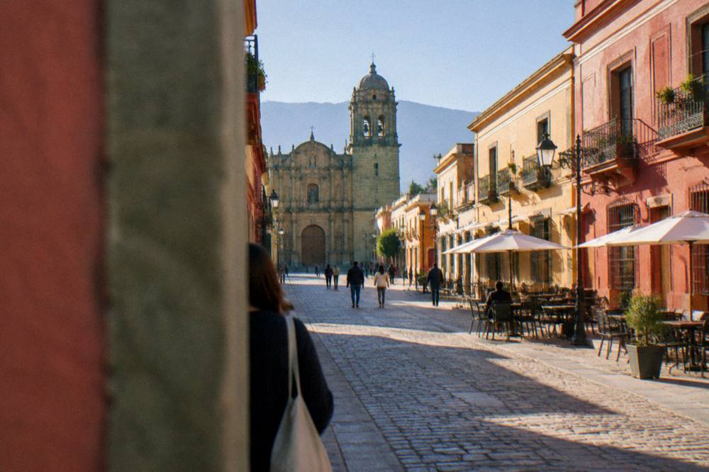 A golden stone church facade and pedestrian street in the historic centre of Oaxaca City