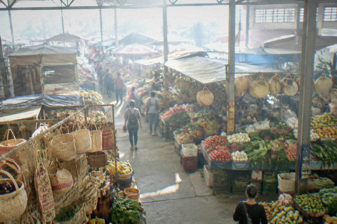 Covered market stalls with hanging woven baskets and fresh produce in central Oaxaca