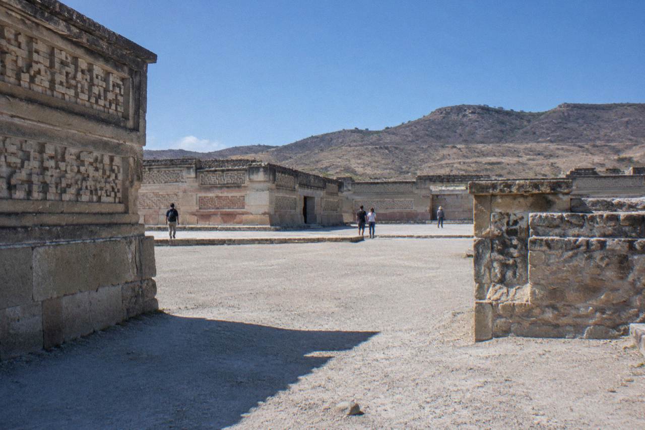 Ancient stone walls with geometric mosaic patterns under a clear sky at an archaeological site
