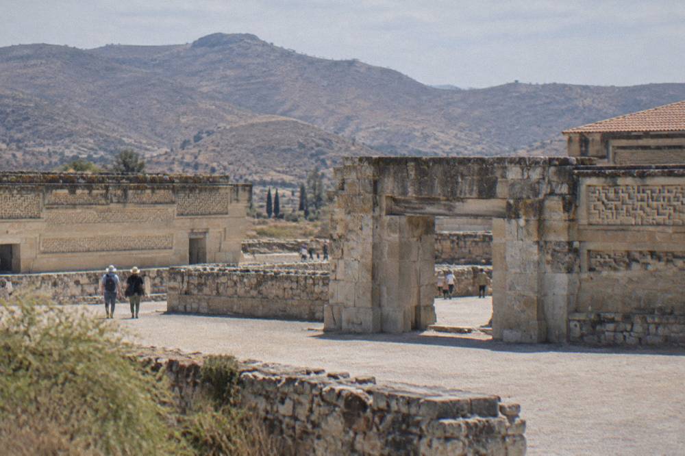 A stone gateway and low ancient walls at an archaeological zone in dry morning light