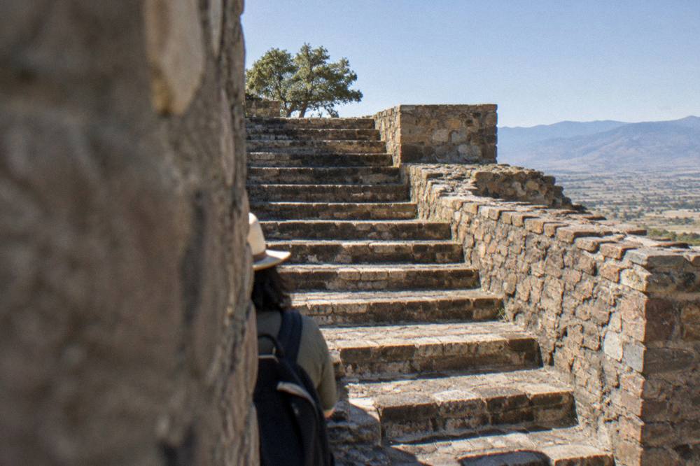 An ancient stone staircase rising between ruin walls under clear sky
