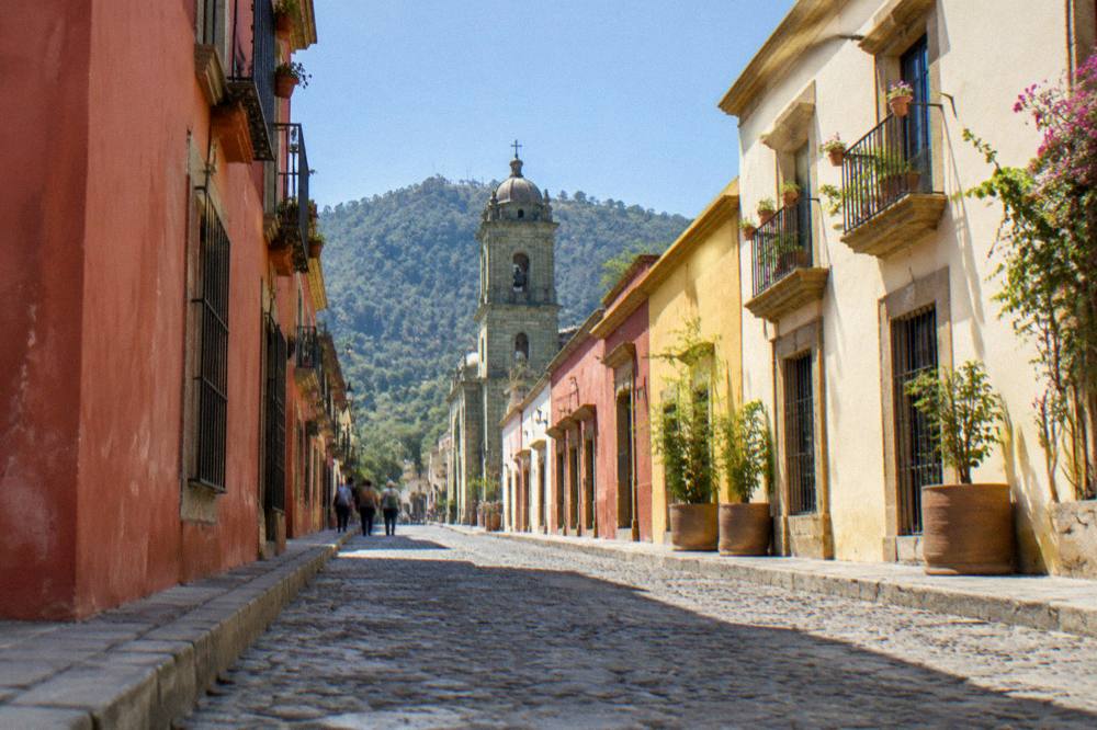 A sunny courtyard in Oaxaca City with warm stone walls and potted plants