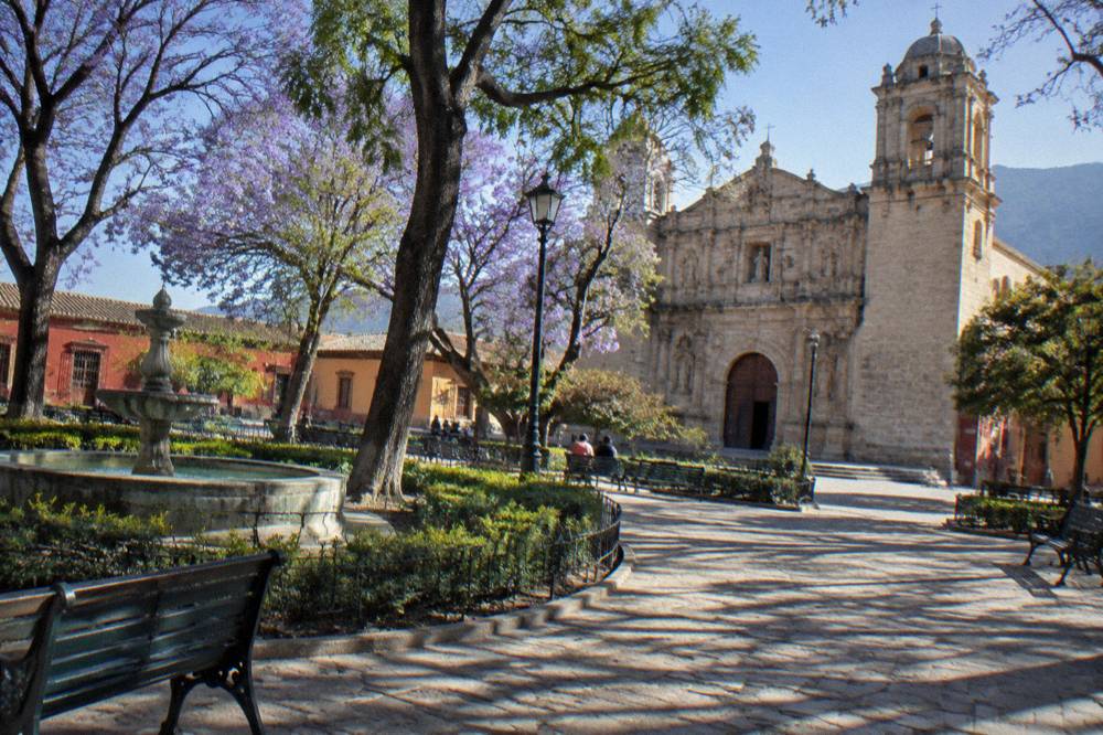 A stone church facade lit by afternoon sun in a Mexican colonial city