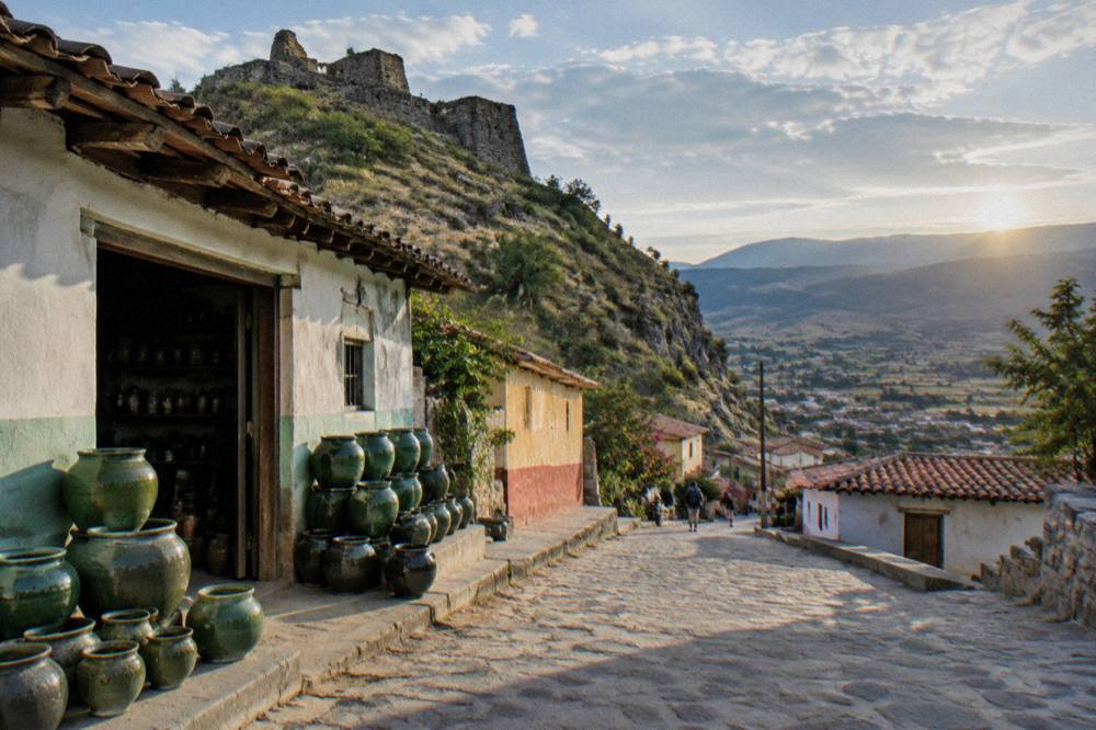 Sunrise light over terraced hills and a valley town in the Oaxaca highlands