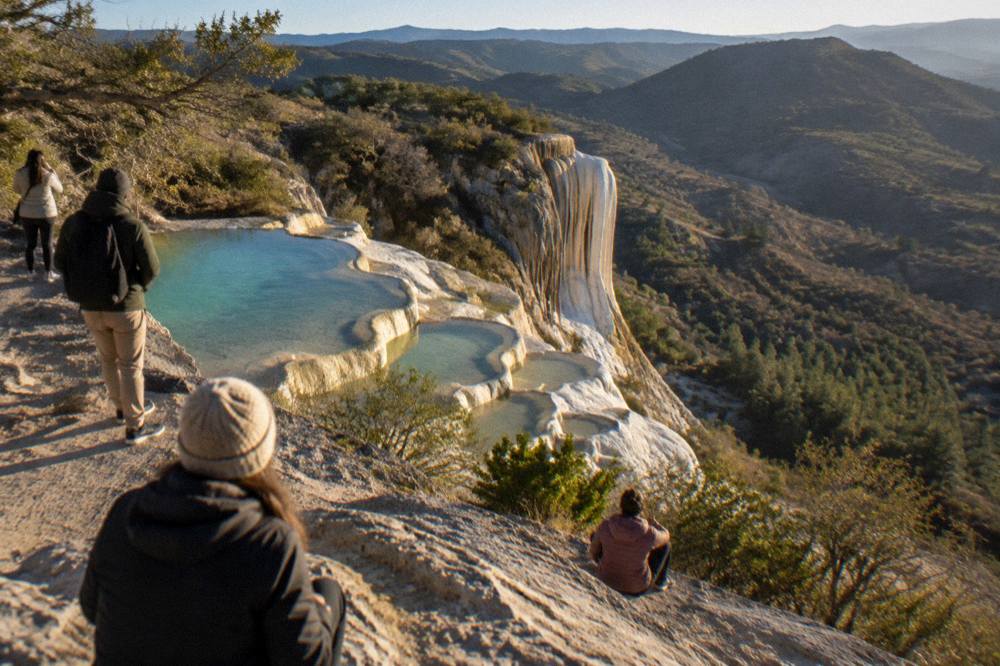 Travellers looking out over the petrified waterfall cliffs from a viewpoint