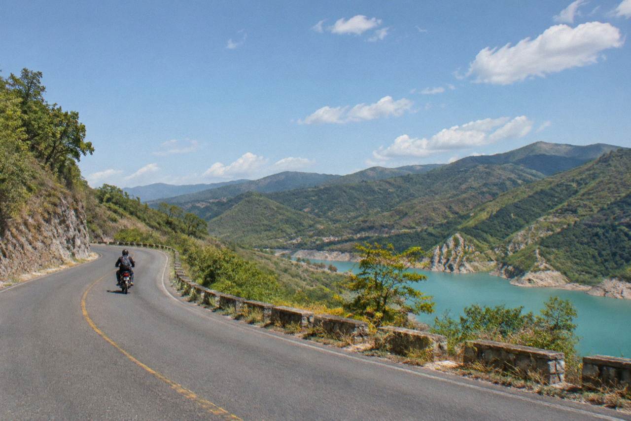 A mountain road winding through green highland hills in southern Mexico