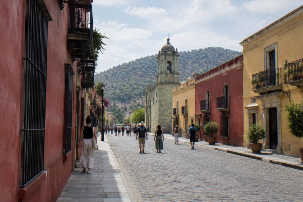 Crowds of visitors walking on the flat plaza of a large archaeological site