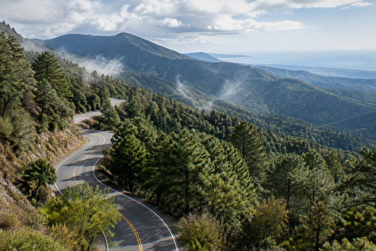 A mountain highway winding through green hills toward the Pacific coast of Oaxaca