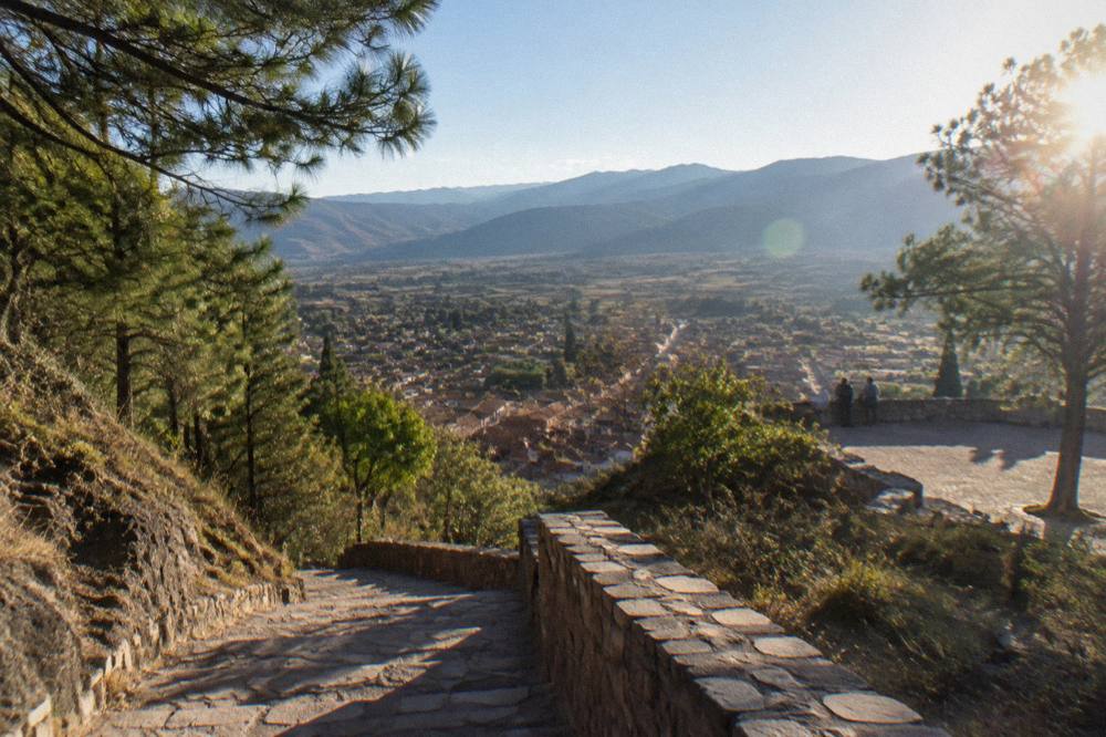 A viewpoint above a valley with terraced fields and distant ridges