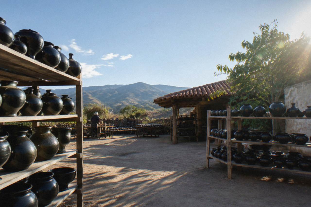 Shelves of glossy black pottery vessels displayed in a workshop in a Oaxacan village