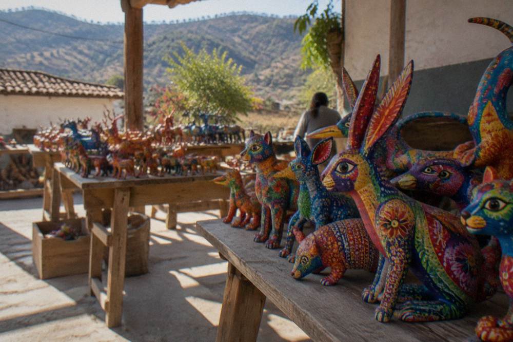 Painted wooden alebrije figures stacked on a table in a craft workshop