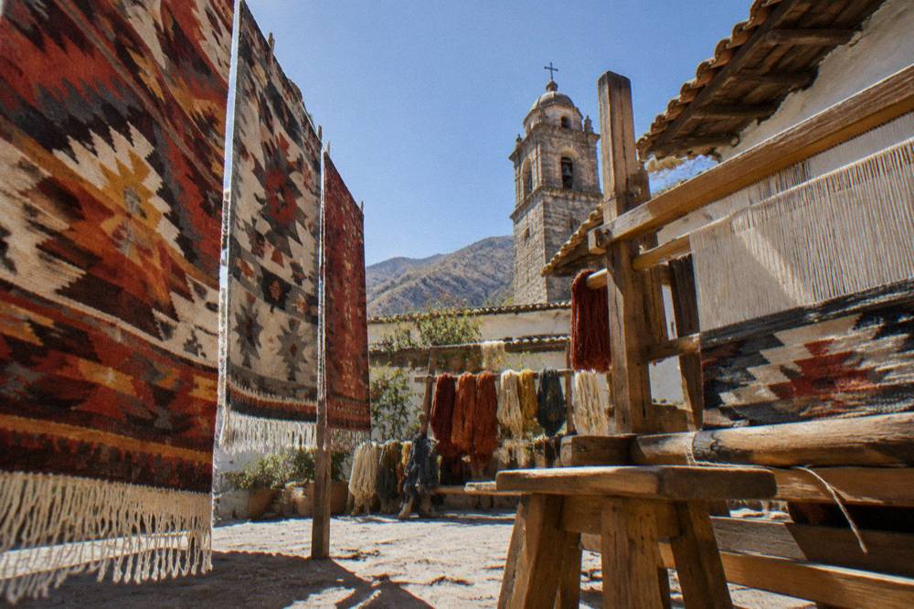 A weaving loom with a partly finished rug inside a family workshop in a valley village