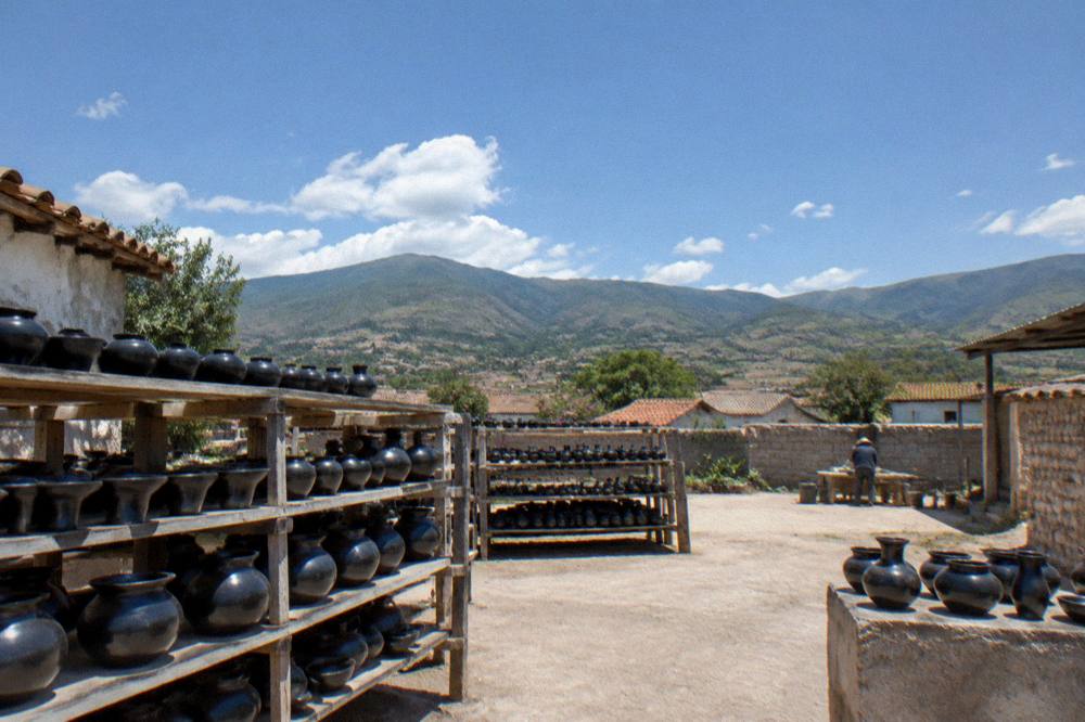 Green valley hills under scattered clouds above village rooftops in Oaxaca