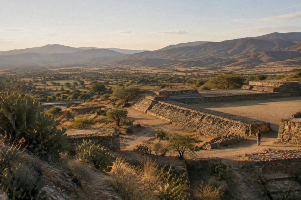 Wide view over the Tlacolula Valley from a ruin site with brown hills under afternoon light