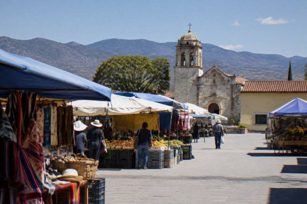 Open-air market awnings along a street in a small Oaxacan valley town on a warm day