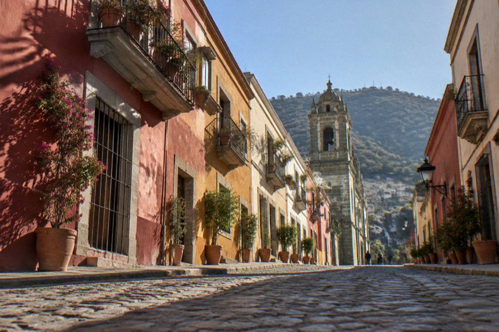 Colourful restored facade with potted plants on a residential Oaxaca street
