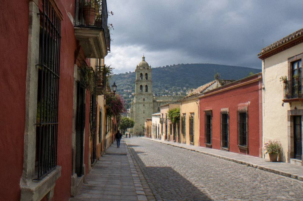 Dark storm clouds gathering over a valley town with tiled rooftops
