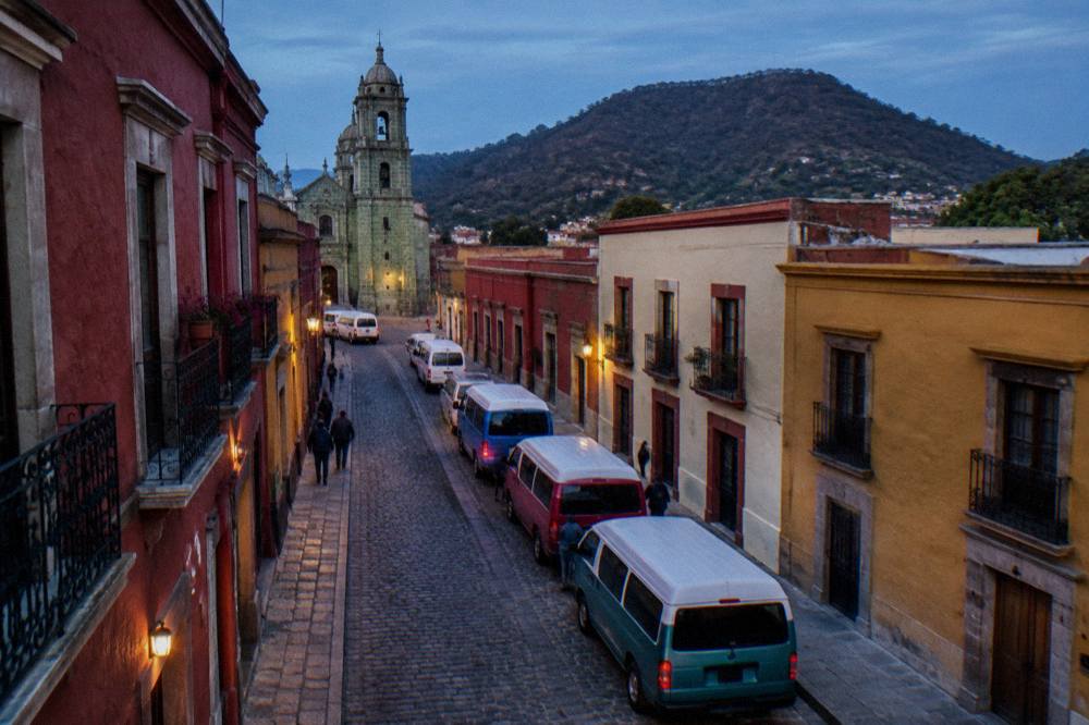 Colourful shared vans parked at a street departure point in Oaxaca