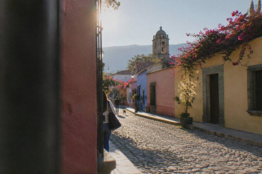 A quiet residential street in the Jalatlaco neighbourhood with murals on the walls