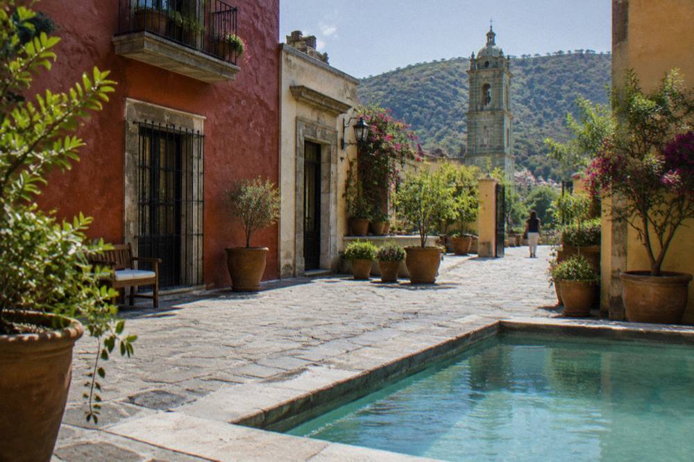 A guesthouse courtyard in Oaxaca with potted plants and a stone floor