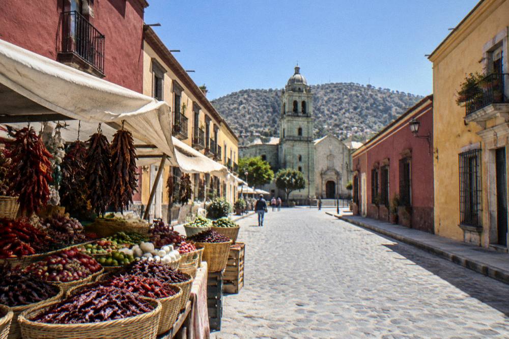 A market stall in Oaxaca with fresh produce and dried chillies displayed in baskets