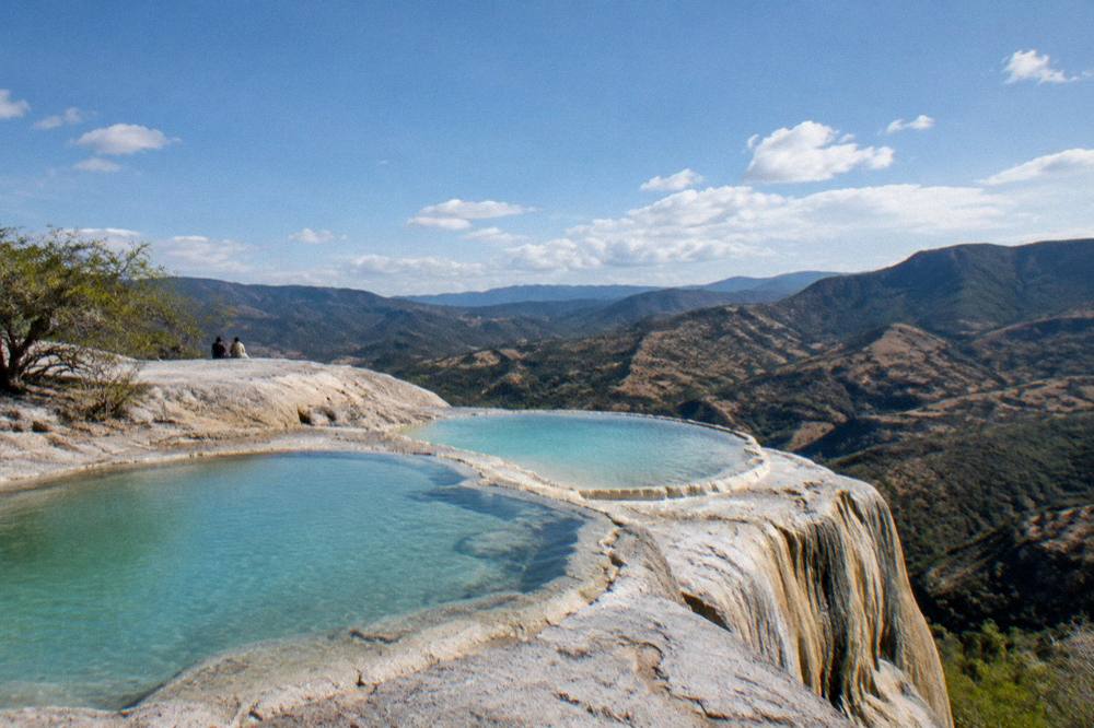Mineral terraces and turquoise pools at Hierve el Agua above a valley