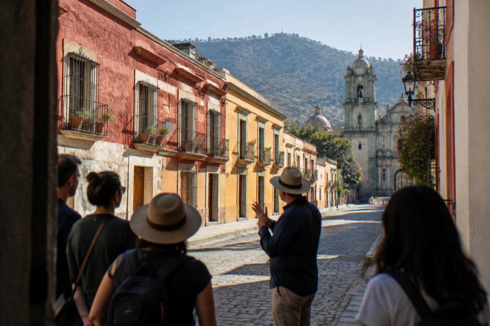 A guide speaking to a small group of visitors on a street in Oaxaca's centre