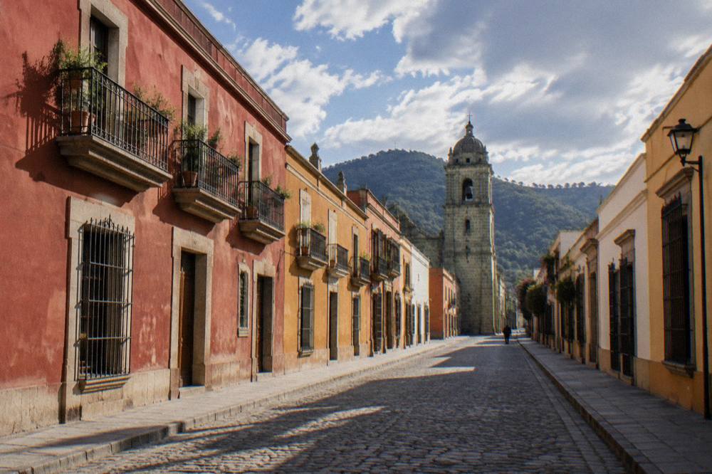 An empty Oaxaca City street in early morning light with long shadows on stone paving