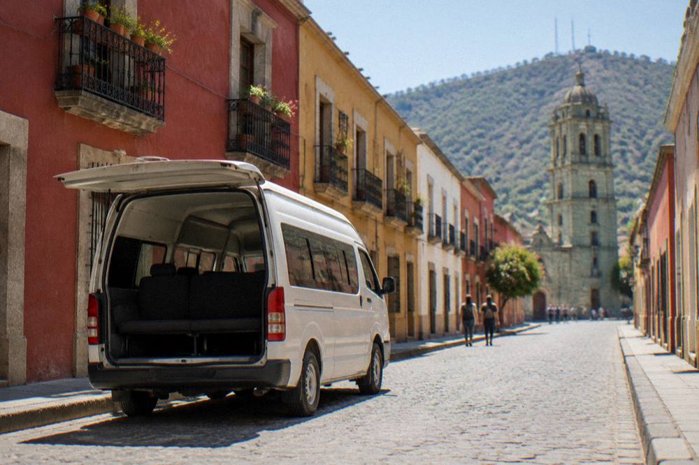 A colectivo van parked on a street in Oaxaca waiting for passengers