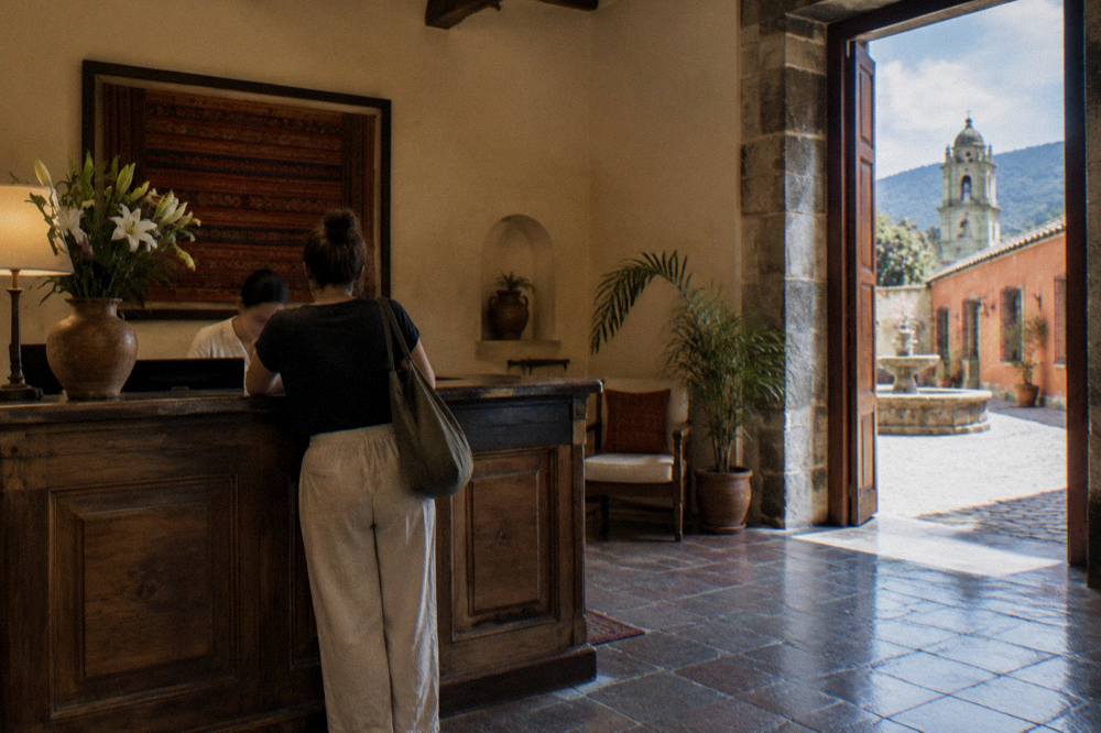 A hotel reception desk in Oaxaca City with a guest settling a bill
