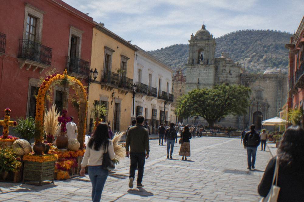 Crowds walking past decorated displays in the main square of Oaxaca City