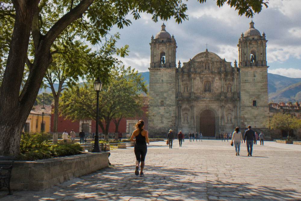 Open plaza with a stone cathedral facade and people strolling in warm afternoon light