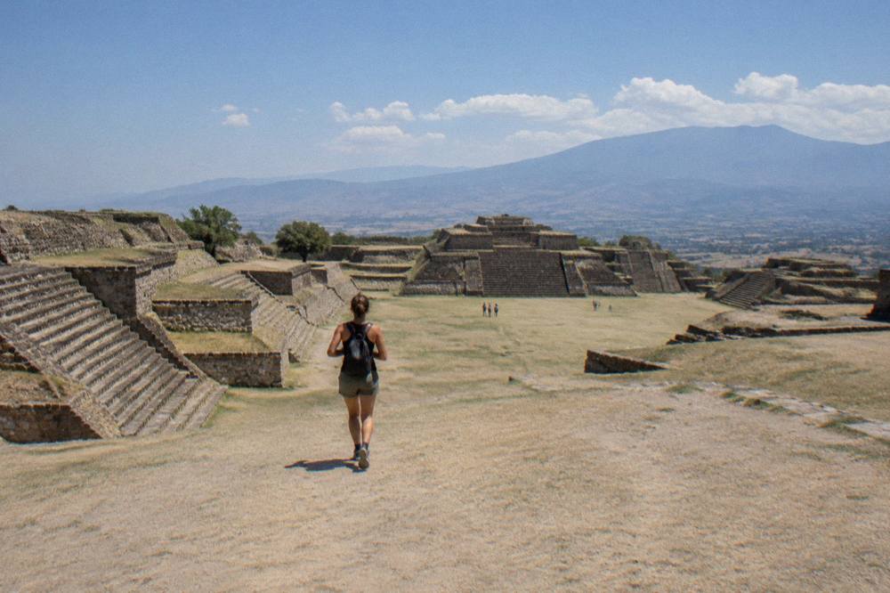 Wide stone terraces of Monte Albán under strong mid-morning sun with valley haze