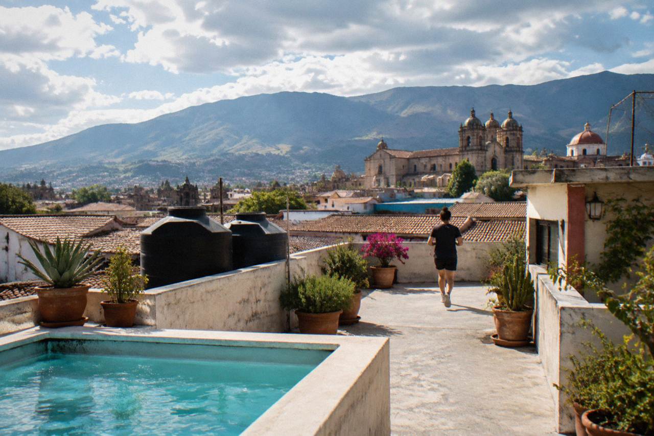 A view over the tiled roofs and church domes of Oaxaca City with mountains behind