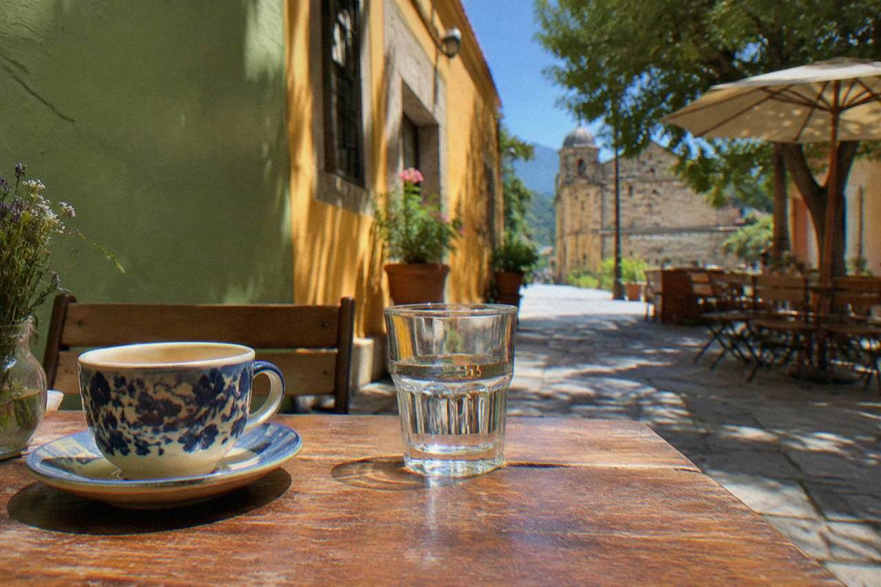 A quiet café terrace in a colonial Oaxaca street with green and ochre walls