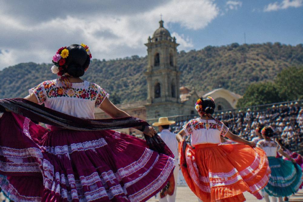Dancers in regional costume performing in a stadium in Oaxaca