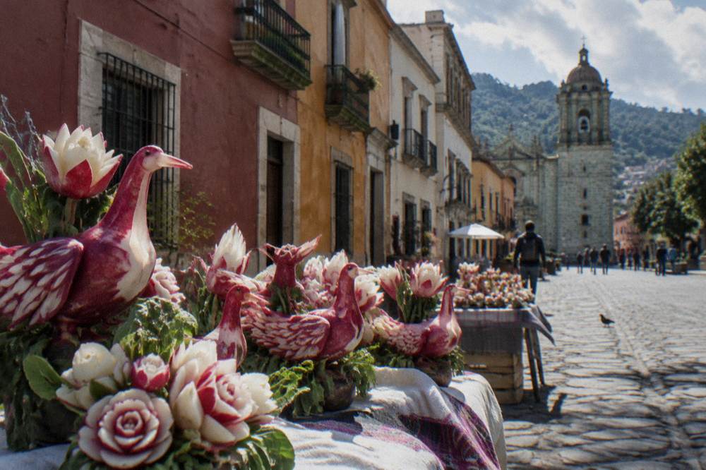 Carved radish figures displayed on tables in a Oaxaca City square