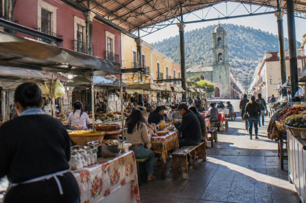 Covered market hall in Oaxaca City with food stalls and people eating