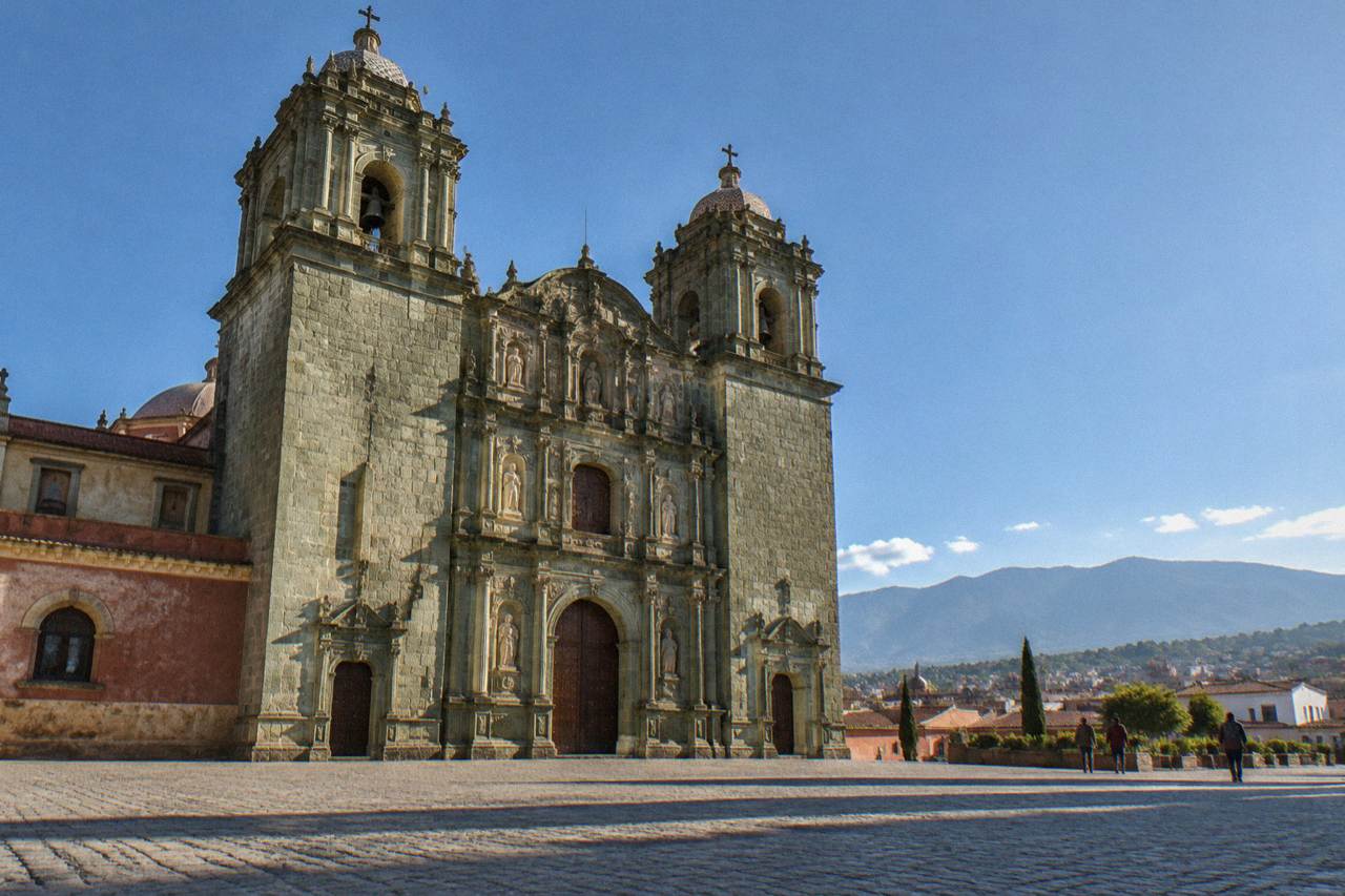 Rooftops of Oaxaca City with the Church of Santo Domingo and mountains on the horizon