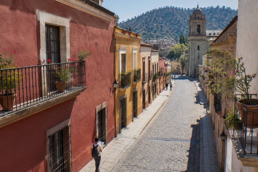 A traveller studying a paper map at an outdoor table in Oaxaca City