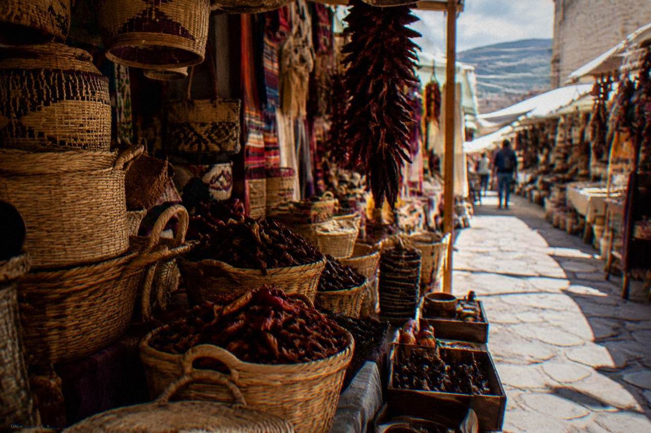 A market stall in Oaxaca City stacked with woven baskets, chillies and handcrafted goods under warm light